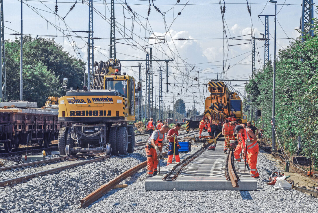 Gleisbaustelle mit Personen und schwerem Arbeitsgerät