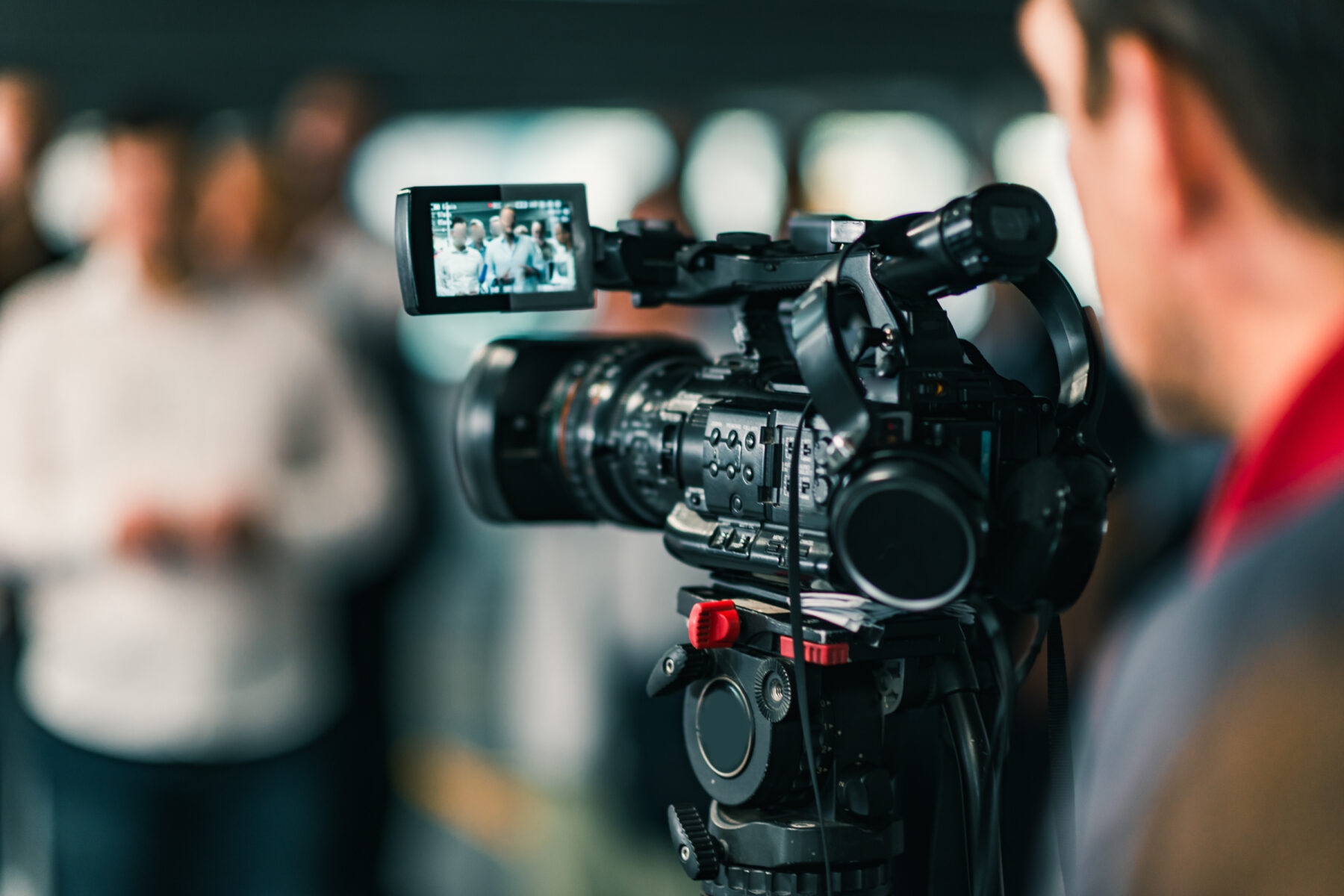 Kameramann, der eine Videoaufnahme von Personen macht