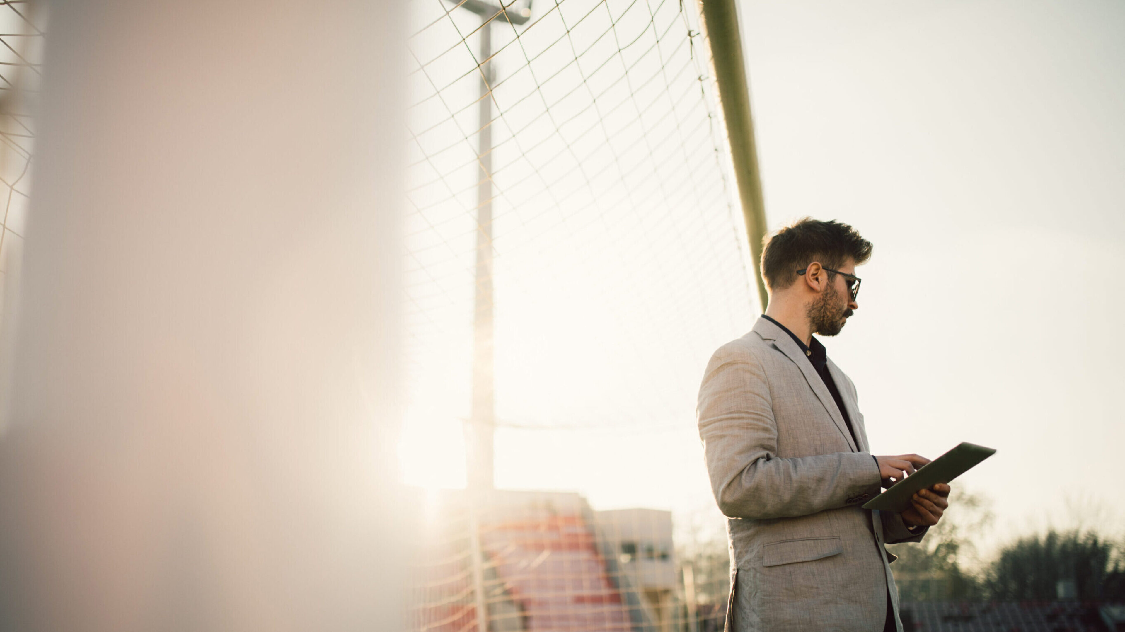 Ein junger Mann steht auf einem Spielfeld vor einem Tor