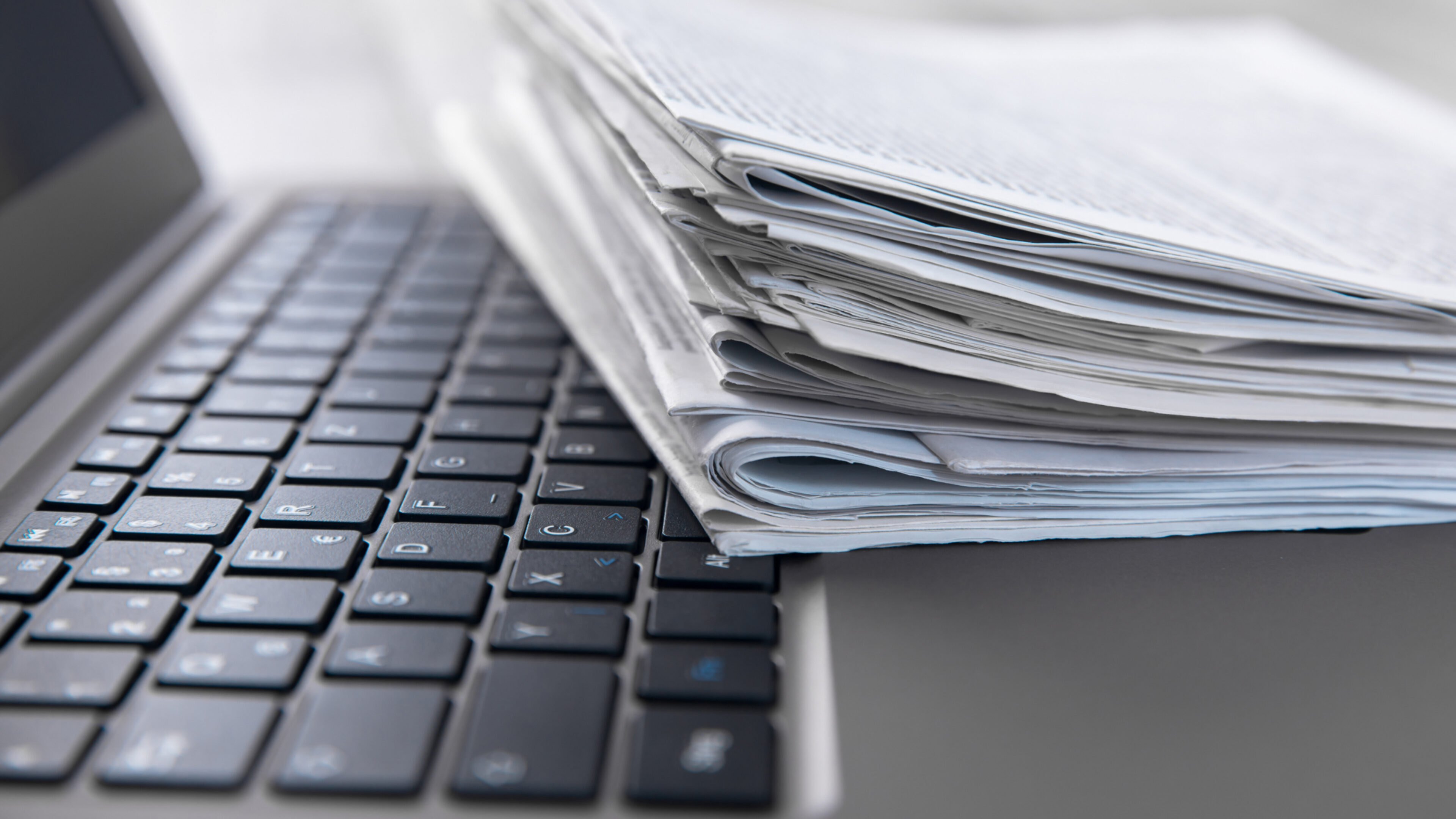 Nahaufnahme Laptop und darauf gestapelten Magazinen