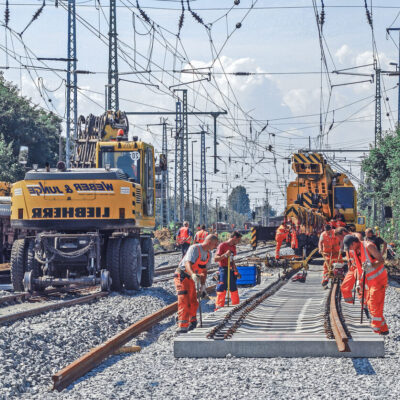 Gleisbaustelle mit Personen und schwerem Arbeitsgerät