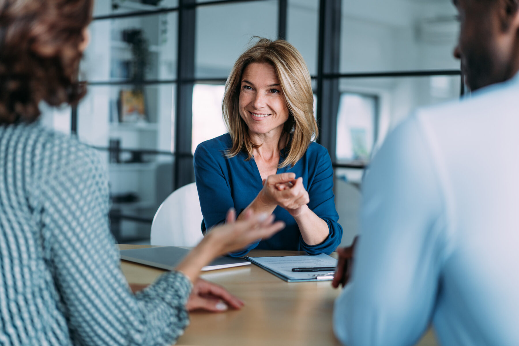Shot of group of business persons in business meeting. Female manager discussing with her colleagues.