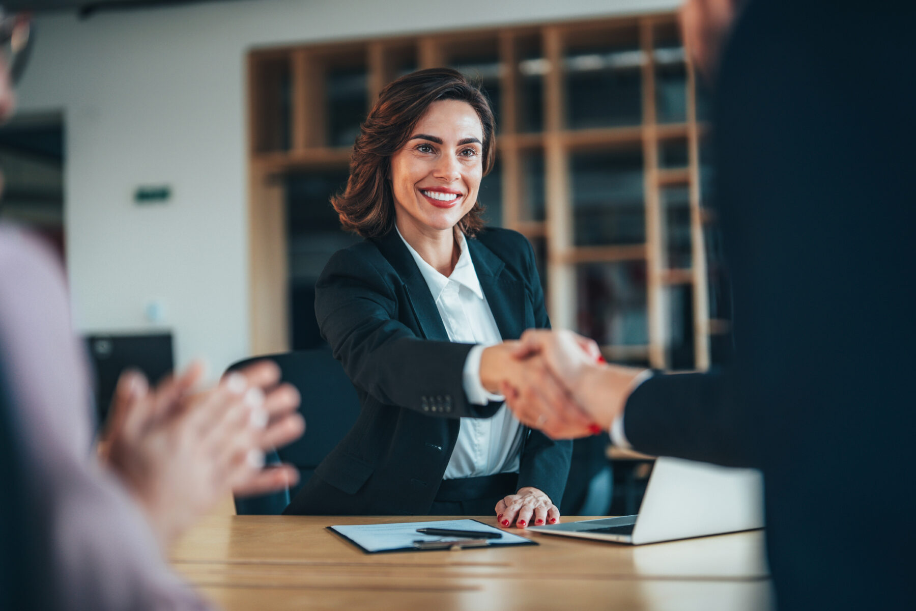Group of three happy people handshake after signing a contract in the office
