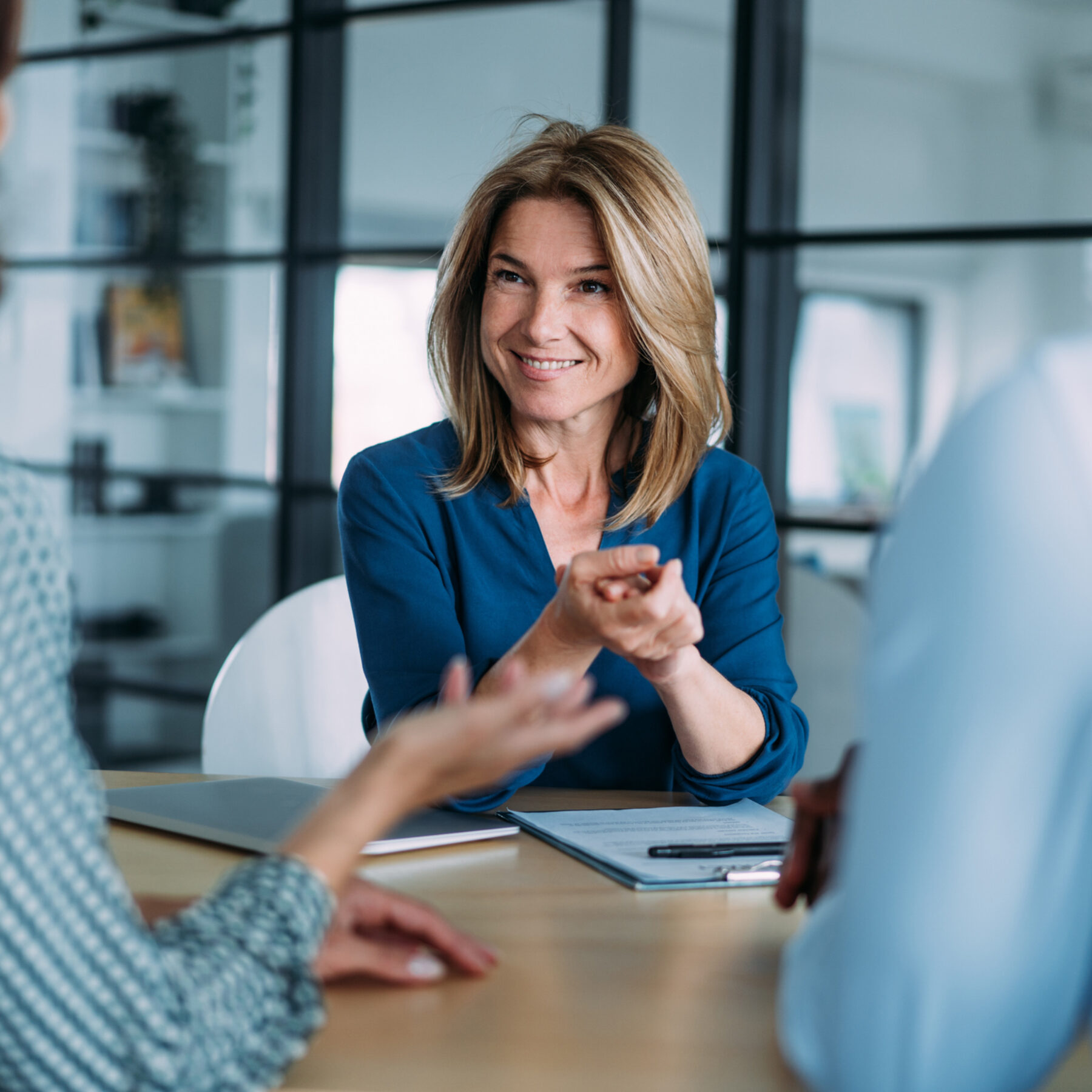 Shot of group of business persons in business meeting. Female manager discussing with her colleagues.