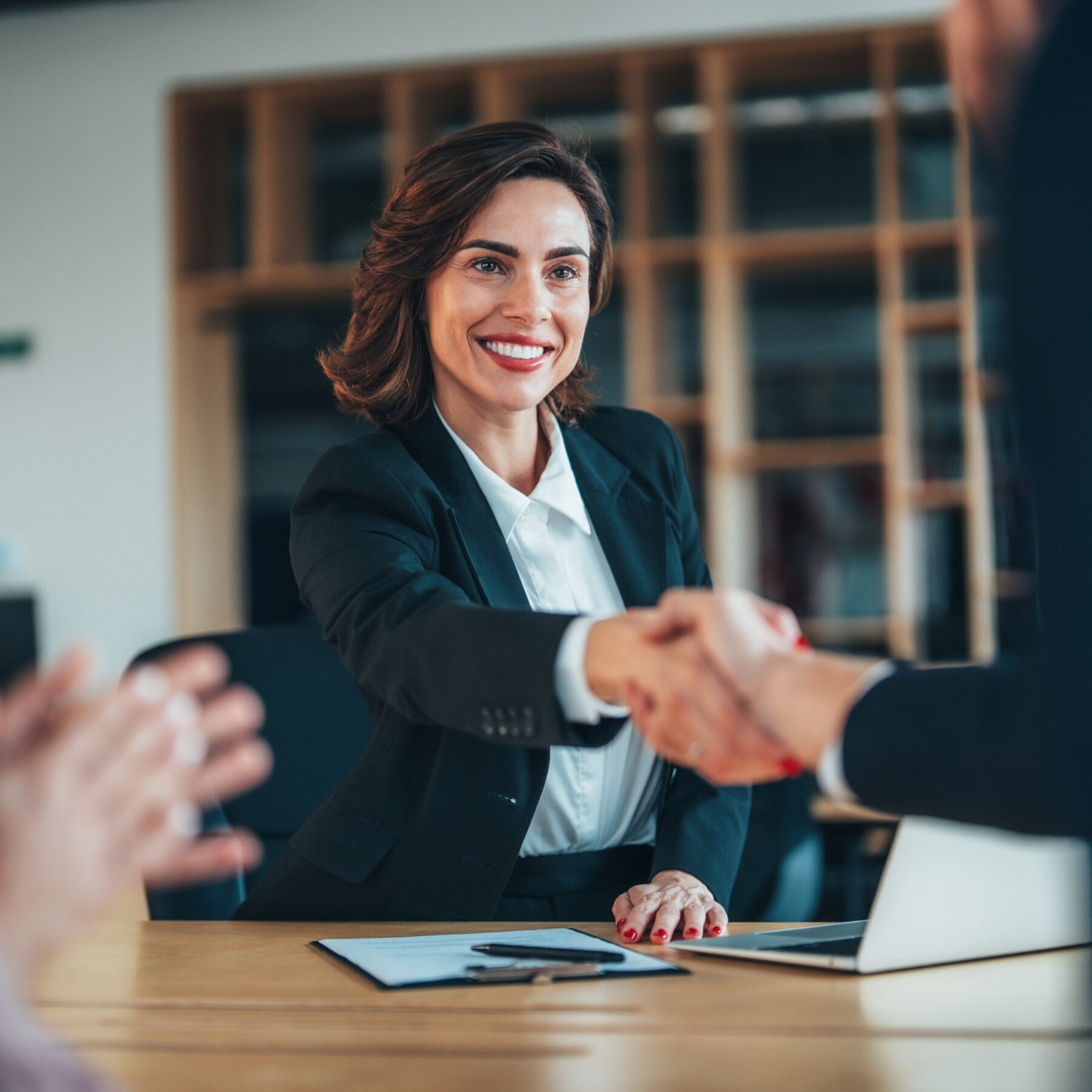 Group of three happy people handshake after signing a contract in the office
