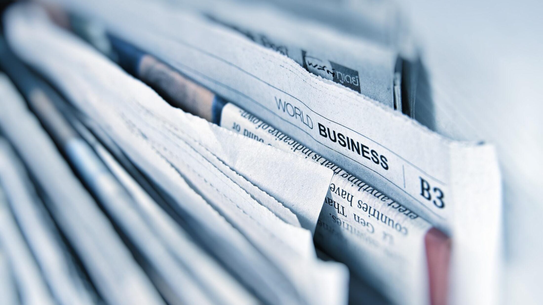 Ein Stapel Zeitungen mit dem Fokuspunkt auf die Überschrift "World Business"